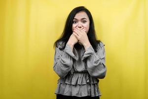 Beautiful young woman surprised, shocked, wow expression, hand covering mouth, presenting something, promoting product, advertisement, isolated photo