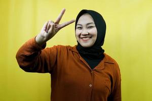 Hermosa joven musulmana asiática con manos firmadas en V, ok, buen trabajo, acuerdo, victoria, mirando a la cámara aislada foto