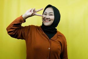 Hermosa joven musulmana asiática con manos firmadas en V, ok, buen trabajo, acuerdo, victoria, mirando a la cámara aislada