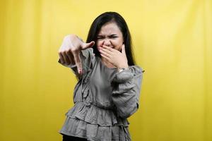 Hermosa mujer joven con la mano cubriendo la boca, la mano apuntando hacia abajo, aislado foto