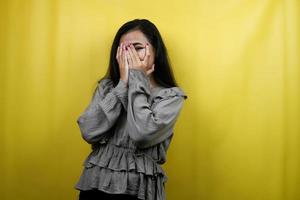 Beautiful young woman with eyes peeking between fingers, isolated photo