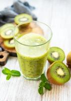 Glass of kiwi smoothie with fresh fruits photo