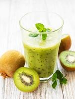 Glass of kiwi smoothie with fresh fruits photo