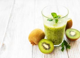 Glass of kiwi smoothie with fresh fruits photo