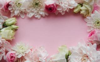 marco de flores sobre fondo rosa pastel. foto