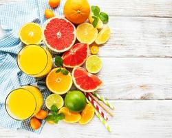 vasos de jugo y frutas cítricas foto