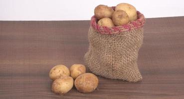 Fresh small potatoes for cooking in a wooden bowl. With copy space  on white background. photo