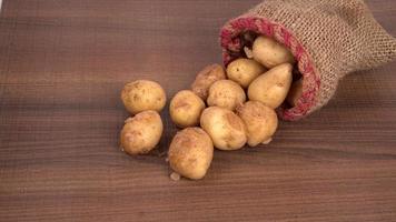 Fresh small potatoes for cooking in a wooden bowl. With copy space  on white background. photo