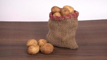 Fresh small potatoes for cooking in a wooden bowl. With copy space  on white background. photo
