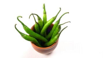 Fresh long Indian green chillies on wooden background. photo