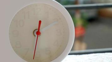 A closeup shot of a white clock with arrows showing time. photo