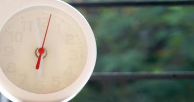 A closeup shot of a white clock with arrows showing time. photo