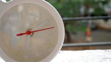 A closeup shot of a white clock with arrows showing time. photo