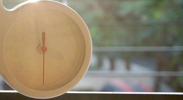 A closeup shot of a white clock with arrows showing time. photo