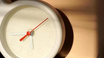 A closeup shot of a white clock with arrows showing time. photo