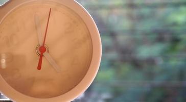 A closeup shot of a white clock with arrows showing time. photo