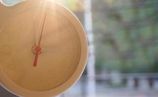 A closeup shot of a white clock with arrows showing time. photo