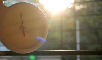 A closeup shot of a white clock with arrows showing time. photo