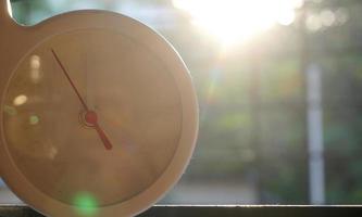 A closeup shot of a white clock with arrows showing time. photo