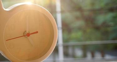 A closeup shot of a white clock with arrows showing time. photo