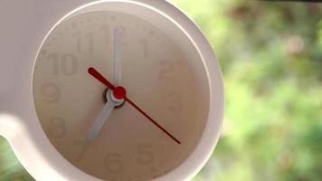 A closeup shot of a white clock with arrows showing time. photo