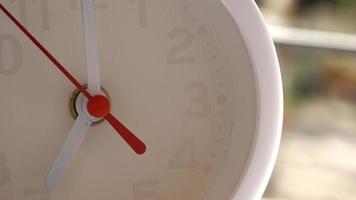 A closeup shot of a white clock with arrows showing time. photo