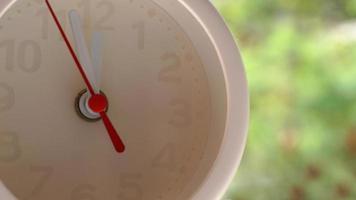 A closeup shot of a white clock with arrows showing time. photo