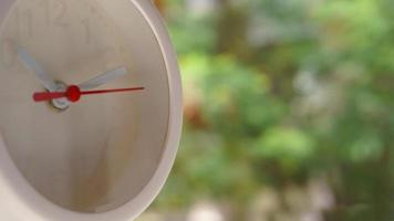 A closeup shot of a white clock with arrows showing time. photo