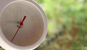 A closeup shot of a white clock with arrows showing time. photo