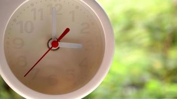 A closeup shot of a white clock with arrows showing time. photo