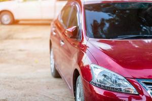 Closeup of headlight ,window of red car outdoors. photo