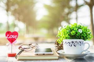 Close-up of empty notebook,smartphone,spectacles and cup of coffee on Marble floor background. Love concept with heart desktop,Valentine's Day. photo