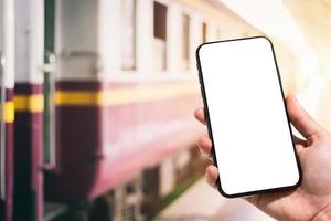 primer plano de uso femenino mano sujetando smartphone imágenes borrosas toque de desenfoque abstracto de desenfocado en la estación de tren el fondo. foto