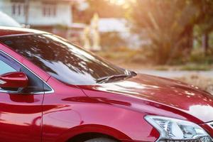 Closeup of headlight ,window of red car outdoors. photo