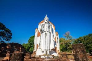 Ancient white buddha statue beautiful at sunset is a Buddhist temple It is a major tourist attraction in Phitsanulok, Thailand. photo