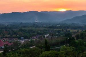 La vista del río y las montañas en la presa de khun dan prakan chon es la presa de concreto compactado con rodillo más grande y más larga del mundo durante la puesta de sol en la provincia de nakonnarok, tailandia. foto