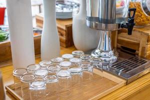 multiple rows of transparent empty glass bottles container for cool water at buffet self service at hotel. photo