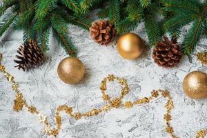 New Year's or Christmas composition of spruce green branches, pine cones and New Year's and shiny golden toys photo