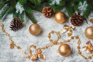 New Year's or Christmas composition of spruce green branches, pine cones and New Year's and shiny golden toys photo