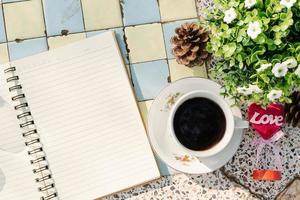 Top view image of empty notebook,spectacles and cup of coffee on Marble floor background. Love concept with heart desktop,Valentine's Day. photo