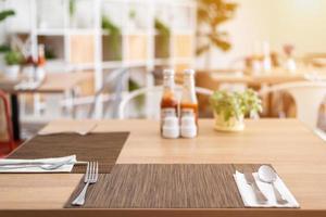 Close-up of luxurious spoon and fork, flower vaseson, sauce bottle the dining table decoration in hotel photo