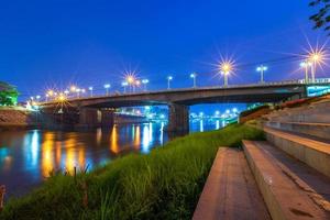 hermosa luz en el río nan por la noche en el puente foto