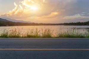 Camino rural con vista panorámica del embalse Huay Tueng Tao con bosque cordillerano al atardecer en Chiang Mai, Tailandia foto