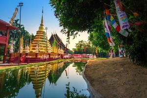 banderas de oración tung cuelgan con paraguas o bandera tradicional del norte cuelgan en la pagoda de arena en el templo phan tao para el festival de songkran se celebra en un día tradicional de año nuevo en chiang mai, tailandia foto