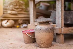 Tarros de barro antiguos tailandeses recolectan carbón usado con mesa de madera son de estilo tradicional tailandés. foto