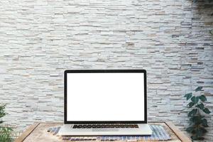 Mockup image of laptop with blank white screen on wooden table with wall large texture background. photo