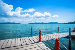 bridge wooden walking way in the sea at Hat chao lao beach blue sky background in Chanthaburi, Thailand.
