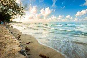 hermoso amanecer temprano en la mañana sobre el cocotero con el mar el horizonte en la playa de hat chao lao en chanthaburi, tailandia. foto