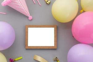 Fondo de feliz cumpleaños, decoración de fiesta colorida laicos plana con marco de fotos sobre fondo gris pastel