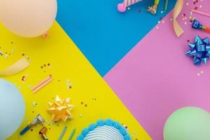 Happy birthday background, Flat lay colorful party decoration on pastel yellow, blue and pink geometric background photo